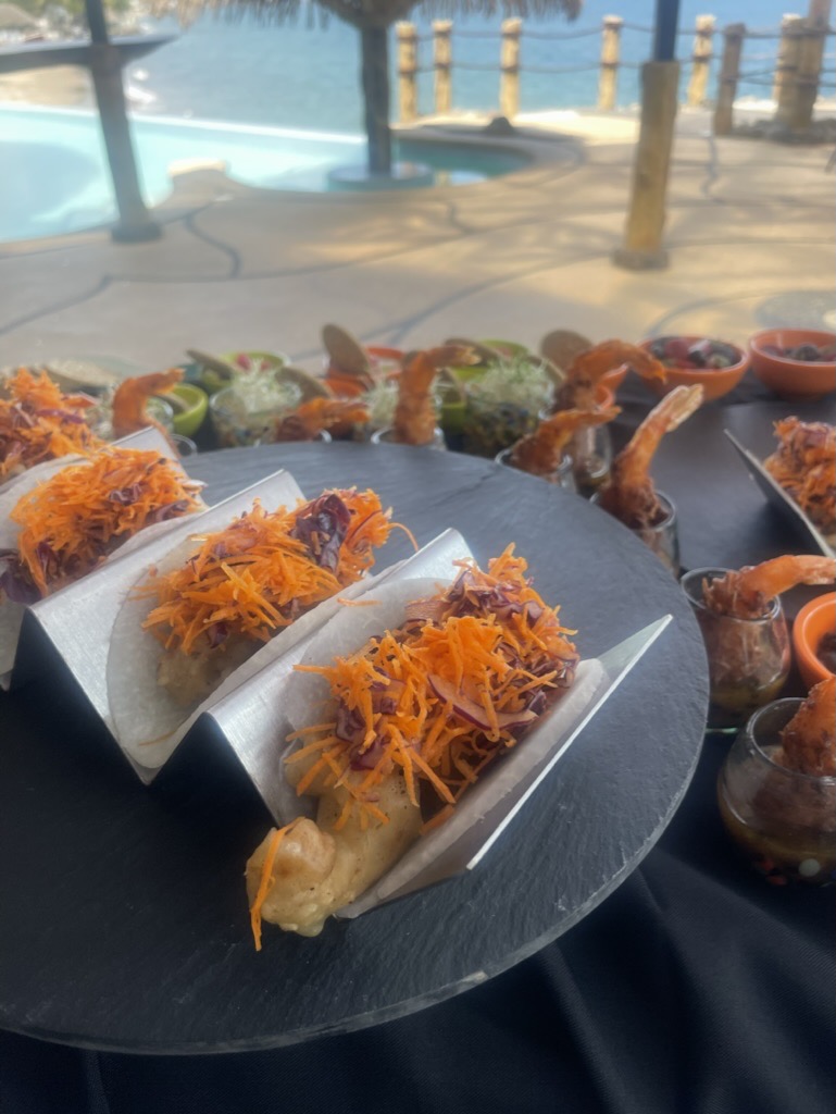 Chef-prepared seafood tacos with the pool and Pacific Ocean in the background